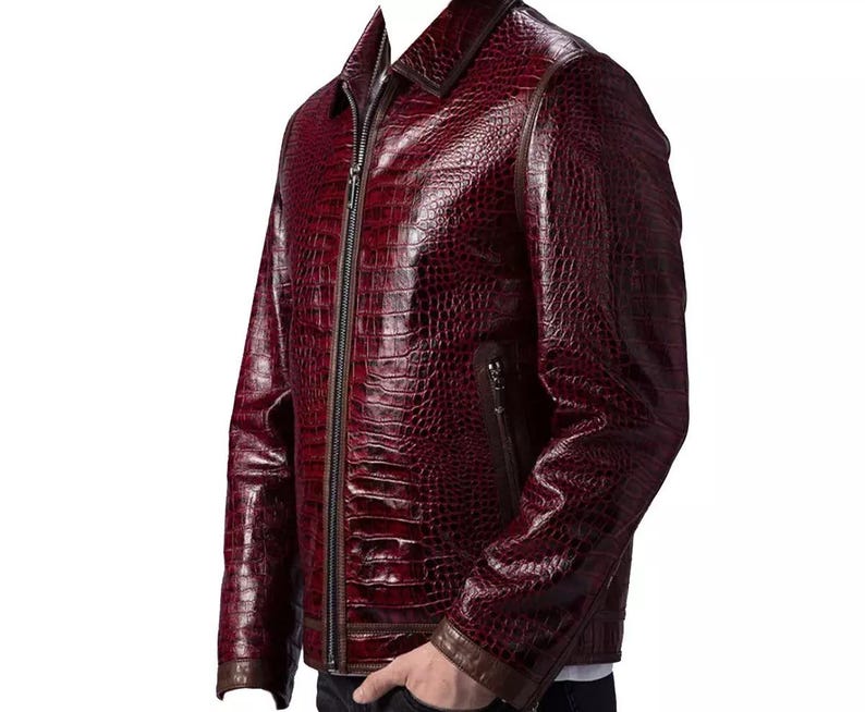 Puede incluir: Chaqueta de cuero burdeos con textura de piel de cocodrilo. La chaqueta tiene cierre de cremallera, cuello y ribete marr&oacute;n en los pu&ntilde;os y el cuello. Corte entallado y dise&ntilde;o cl&aacute;sico.