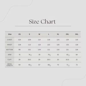 May include: A size chart with measurements in centimeters for chest, waist, bottom, arm, cuff, and back length. Sizes range from XS to 3XL. The chart is displayed on a light beige background.
