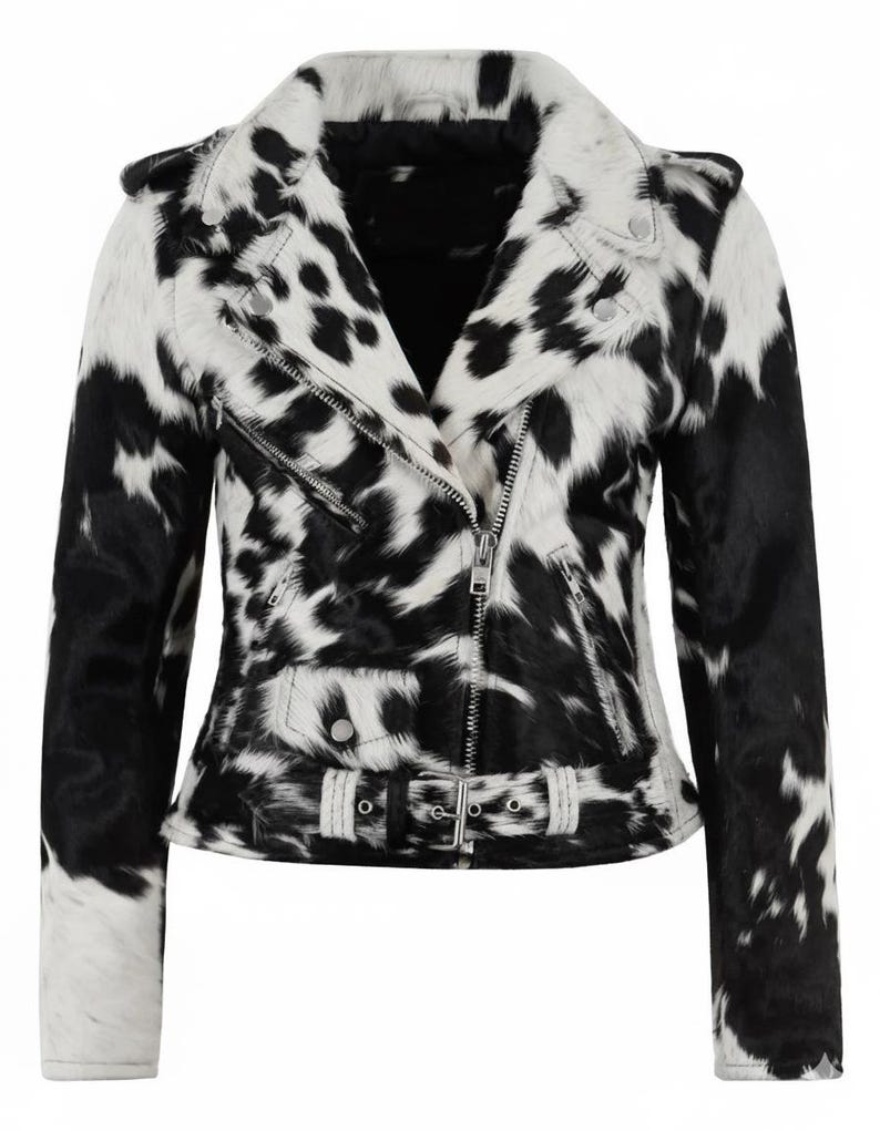 May include: A moto-style jacket featuring a black and white cow-print pattern with a textured finish. The jacket includes a notched lapel, an asymmetrical silver-tone metal zipper closure, zippered pockets, shoulder epaulets, and a buckled waist belt.