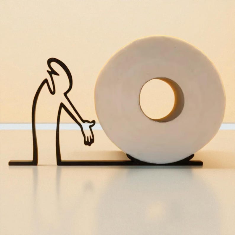 May include: A whimsical toilet paper holder featuring a black metal silhouette of a person reaching towards a roll of white toilet paper. The holder has a minimalist design, suitable for a modern bathroom.