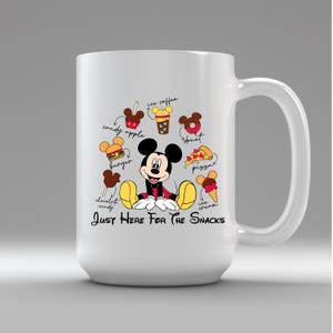 Puede incluir: Taza de cer&aacute;mica blanca con Mickey Mouse e ilustraciones de snacks como una manzana caramelizada, hamburguesa y pizza. El texto "Just Here For The Snacks" est&aacute; debajo. Un dise&ntilde;o divertido con tem&aacute;tica de comida.