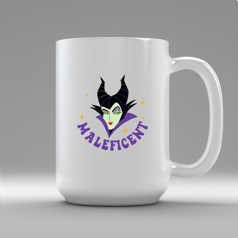 Puede incluir: Taza de cer&aacute;mica blanca con una imagen de dibujos animados de Mal&eacute;fica, con cuernos negros, piel verde y un cuello morado. La palabra "Mal&eacute;fica" est&aacute; en escritura morada. La taza tiene un asa grande.