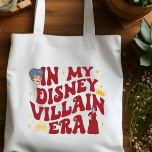 May include: White tote bag with the text "IN MY DISNEY VILLAIN ERA" in red, with illustrations of Disney villains. The bag has two handles and is made of a sturdy material, perfect for carrying items.