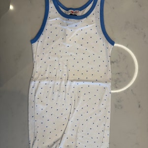 May include: White tank top with a blue trim and a small blue triangle pattern.