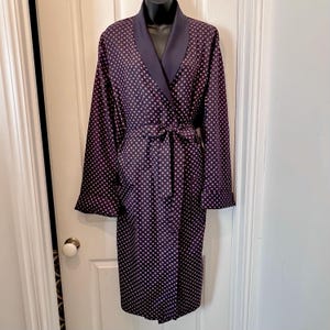 Puede incluir: Una bata de manga larga con una base de color morado oscuro y un patrón repetitivo de pequeños rombos blancos y rosa claro. La prenda incluye un cuello chal de color morado oscuro sólido, mangas largas con puños y un cinturón de tela a juego.