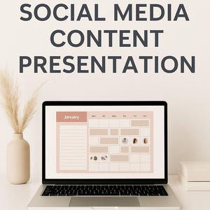 May include: A laptop screen shows a social media content calendar for January. The screen has a pink and beige layout with content planning spaces. The text at the top reads "MONTHLY SOCIAL MEDIA CONTENT PRESENTATION." The bottom text says "DIGITAL LOFT DESIGNS."