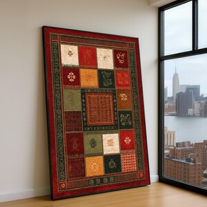 Puede incluir: Una alfombra rectangular enmarcada con un diseño de patchwork. La alfombra presenta un borde rojo y un patrón central de cuadrados en varios colores, incluyendo rojo, verde, dorado y crema. Los cuadrados contienen patrones florales y geométricos.