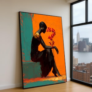 May include: Abstract art print featuring a seated figure with a bald head and a long black dress. The figure is holding red flowers against a vibrant orange and teal background. The artwork is framed in black.