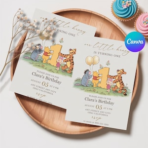 Könnte beinhalten: Zwei Einladungen zum ersten Geburtstag von Clara mit Winnie-the-Pooh-Figuren. Die Einladungen befinden sich auf einem Holztablett, mit Cupcakes im Hintergrund. Der Text lautet "Clara's Birthday" und "August 05 at 3 PM".