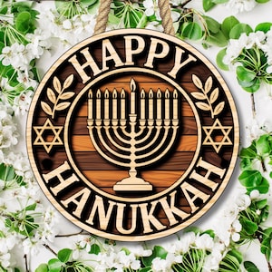 May include: Circular wooden sign with the text "HAPPY HANUKKAH". The design includes a menorah, Star of David, and leaf details. A rope is attached for hanging. The background is white with green leaves and white flowers.