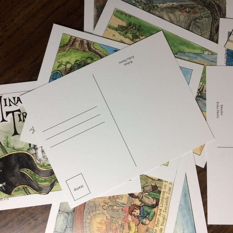 K&ouml;nnte beinhalten: Ein Stapel Postkarten mit Illustrationen von Fantasy-Szenen. Die R&uuml;ckseite der Postkarten ist leer, mit Platz f&uuml;r eine Briefmarke und eine Adresse. Der Text auf den Postkarten lautet "Mordor", "Rohan", "Erika Heins" und "St. Beer and Lodging in E. No Nazg&uuml;l Incidents since 31".
