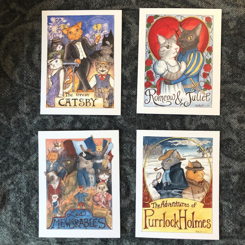 May include: Four illustrated cards featuring cats in various scenes. The first card depicts a group of cats in a scene reminiscent of "The Great Gatsby" with the title "The Great Catsby". The second card features two cats in a romantic scene with the title "Romeow & Juliet". The third card shows a group of cats in a scene reminiscent of "Les Miserables" with the title "Les Mewserables". The fourth card features two cats in a scene reminiscent of "Sherlock Holmes" with the title "The Adventures of Purrlock Holmes".