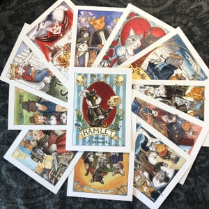 May include: A set of 10 illustrated cards featuring cats in various scenes. The cards are white with black borders and feature colorful illustrations. The cards are titled "Hamlet, Prince of Denmark" and "The Adventures of the Cat-illac Kids".