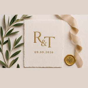May include: A cream-colored wedding invitation with gold embossed initials "R&T" and the date "09.09.2026". The invitation is accompanied by a gold wax seal, olive branches, and a cream-colored ribbon.