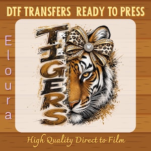 Op de afbeelding: Een DTF-transfer klaar om te persen met het woord TIGERS in een verweerd penseellettertype naast een tijgergezicht met een strik met luipaardprint en een centrale strass-steen. Het ontwerp bevat de tekst DTF TRANSFERS READY TO PRESS en Eloura.