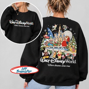 Op de afbeelding: Een zwart sweatshirt met lange mouwen met een afbeelding op de voorkant met de tekst Walt Disney World Where dreams come true en een afbeelding op de achterkant met een kasteel, monorail en diverse Disney-figuren met de tekst Walt Disney World.