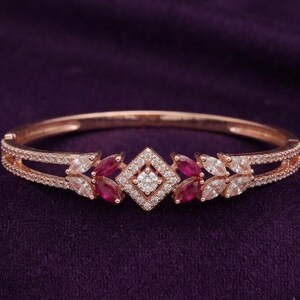 Pulseira elegante em prata banhada a ouro 14k com rubis e diamantes em formato de marquise com motivos florais em estilo Art Déco.