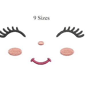 Pode incluir: Design bordado de um rosto sorridente com os olhos fechados. O rosto apresenta cílios pretos, um pequeno nariz rosa, duas bochechas rosas e uma boca rosa curvada. O texto "9 Sizes" está acima do rosto.
