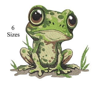 Può includere: Un ricamo di una rana con grandi occhi espressivi e un motivo maculato verde e marrone. La rana è seduta su un pezzo di terra con fili d'erba. Il testo "6 Sizes" si trova nell'angolo in alto a sinistra.