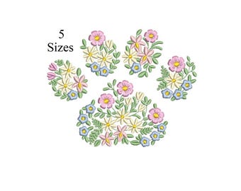 Könnte beinhalten: Gesticktes Pfotenabdruck-Design mit rosa, gelben und blauen Blumen und grünen Blättern. Der Text "5 Größen" befindet sich über dem Pfotenabdruck. Das Design befindet sich auf weißem Hintergrund.