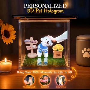 May include: A clear acrylic display case with a 3D pet hologram. The hologram features a white dog wearing a blue sweater, a wooden sign that says "happy", and a small box of yellow flowers. The text reads "PERSONALIZED 3D Pet Hologram".