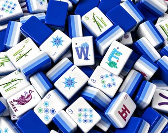 May include: A collection of rectangular mahjong tiles featuring white faces with blue, green, and purple printed designs including bamboo stalks, floral patterns, the letter W, the letter E, and a purple tiger labelled with the word JOKER.