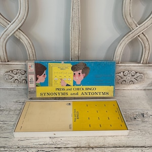 May include: Vintage Milton Bradley "Press and Check Bingo" game. The box is blue with illustrations of children and the game title. The game includes yellow bingo cards and a white tray. The game is designed for intermediate grades.