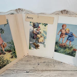 May include: A vintage educational flip chart featuring three illustrated panels. The left panel shows a child in a pink dress, the center panel labeled Jerry shows a child in a wagon with a dog, and the right panel shows two children with a puppy.