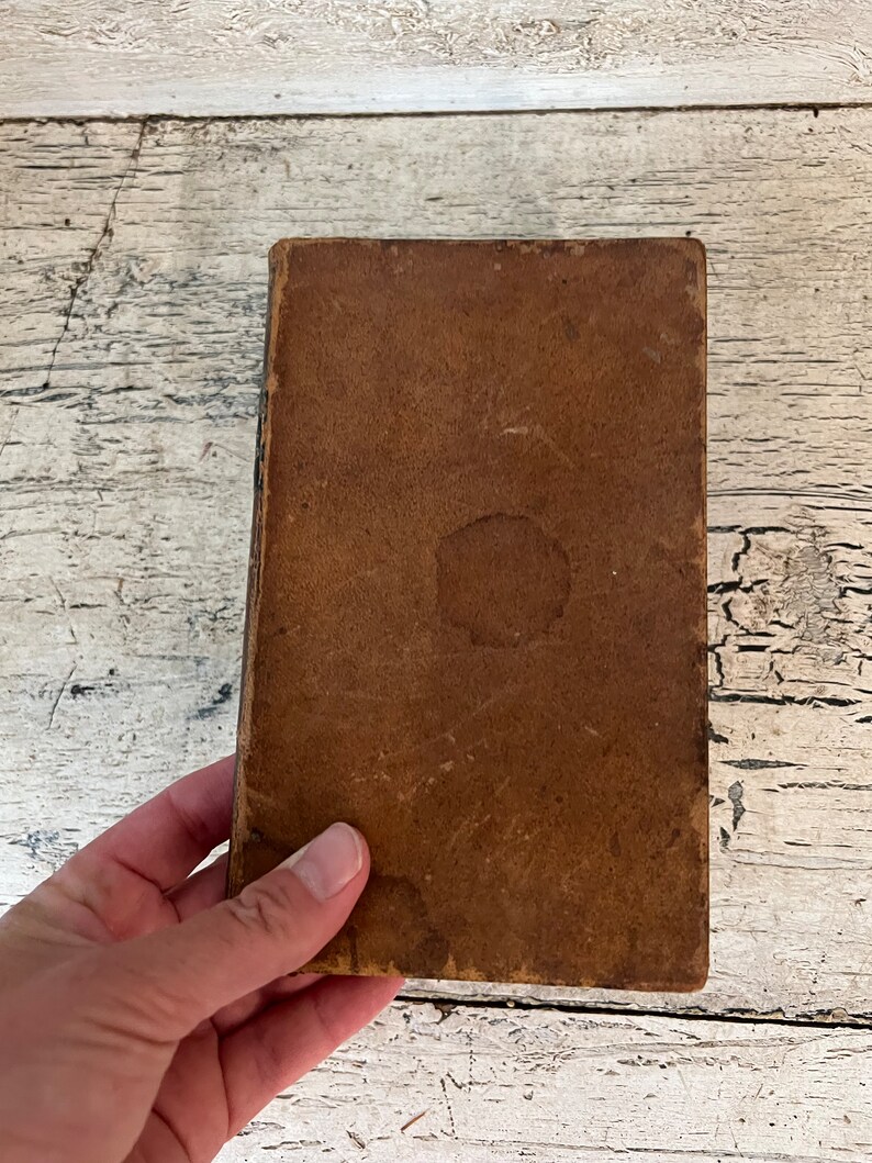May include: A brown leather-bound book with a worn cover.