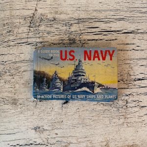 May include: A white ceramic mug with a black handle and the text "But First, Coffee" in a handwritten style. The mug is on a white surface. The mug is approximately 4 inches tall.