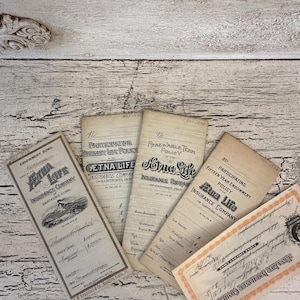 May include: A collection of vintage insurance documents from the Aetna Life Insurance Company. The documents are aged with a sepia tone, featuring detailed text and illustrations. The documents are arranged on a distressed, white wooden surface.