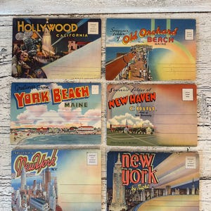May include: Six vintage postcards featuring travel destinations. Postcards include "Hollywood California", "Old Orchard Beach Maine", "York Beach Maine", "New Haven Conn.", "New York N.Y.", and "New York by Night". Each postcard has a unique illustration and text.