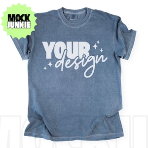 May include: A blue t-shirt with the words "YOUR design" in white script. The shirt has a vintage, washed look. A green starburst graphic with the words "MOCK JUNKIE" is in the upper left corner.