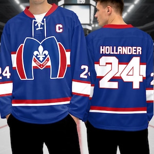 Könnte beinhalten: Ein blaues Hockey-Trikot mit roten und weißen Akzenten. Auf der Vorderseite befindet sich ein Logo mit einer Lilie und dem Text "EST 1909". Auf der Rückseite stehen der Name "HOLLANDER" und die Nummer "24".