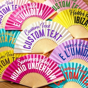 May include: A collection of folding hand fans in various colors including pink, yellow, turquoise, and purple. Each fan features wooden ribs and printed text such as Custom Text, Hotter than IBIZA, non è il caldo E L'UMIDITÀ, and Summer glow HUMID UNDERTOW.