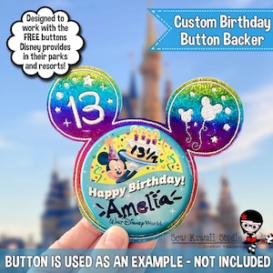 May include: A custom birthday button backer in the shape of Mickey Mouse ears. The design features a colorful rainbow gradient, the number 13, Mickey Mouse, and the text "Happy Birthday! Amelia-" and "Walt Disney World."