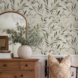 Peut inclure: Une commode en bois rustique avec un grand miroir en arc et un petit miroir encadré. Un vase blanc avec de la verdure est posé sur la commode, avec des livres et un bol. Un coussin à motifs repose sur une chaise en bois.