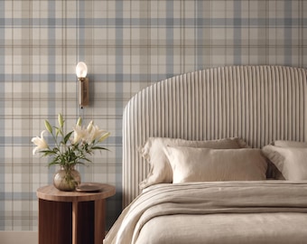 Könnte beinhalten: Ein Schlafzimmer mit einem abgerundeten Kopfteil mit vertikalen Nadelstreifen, beiger Bettwäsche und einem runden Nachttisch aus Holz. Eine Glasvase mit weißen Lilien steht neben einer Wandleuchte vor einer karierten Tapete in Blau und Beige.