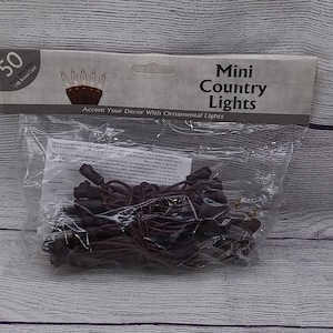 May include: A package of 50 mini country lights with brown wire. The lights are clear and the package says "Accent Your Decor With Ornamental Lights".