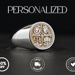 Puede incluir: Un anillo plateado con un emblema circular que presenta un león, un búho, una balanza y una flor de loto, con las palabras "Coraje", "Sabiduría", "Justicia" y "Templanza". La palabra "PERSONALIZADO" está en la parte superior.