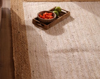 Alfombra de yute blanca hecha a mano con borde beige y trenzado bohemio.