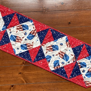 May include: A handmade wooden sign with the text "Welcome" in a handwritten style. The sign is painted white with a distressed finish, and a small green leaf is attached to the top. The sign measures approximately 12 inches wide.