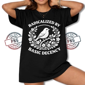 May include: Black t-shirt featuring a white illustration of a bird perched on a branch, surrounded by floral elements. The text "RADICALIZED BY BASIC DECENCY" is displayed in a circular design. The shirt has a relaxed fit.