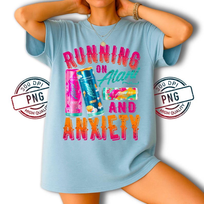 May include: Light blue t-shirt with the text "RUNNING ON Alani AND ANXIETY" in pink and orange. The shirt features three Alani energy drink cans in pink, blue, and pink with various flavors.