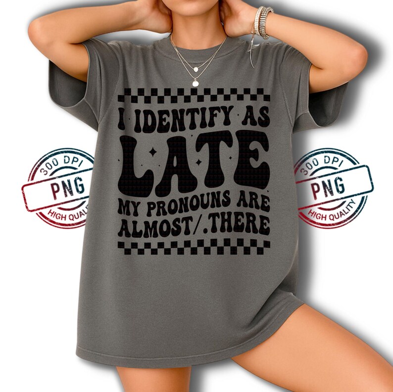 May include: Gray t-shirt with the text "I IDENTIFY AS LATE, MY PRONOUNS ARE ALMOST/.THERE" in black. The shirt has a checkerboard pattern above and below the text. A "300 DPI PNG HIGH QUALITY" stamp is on the shirt.