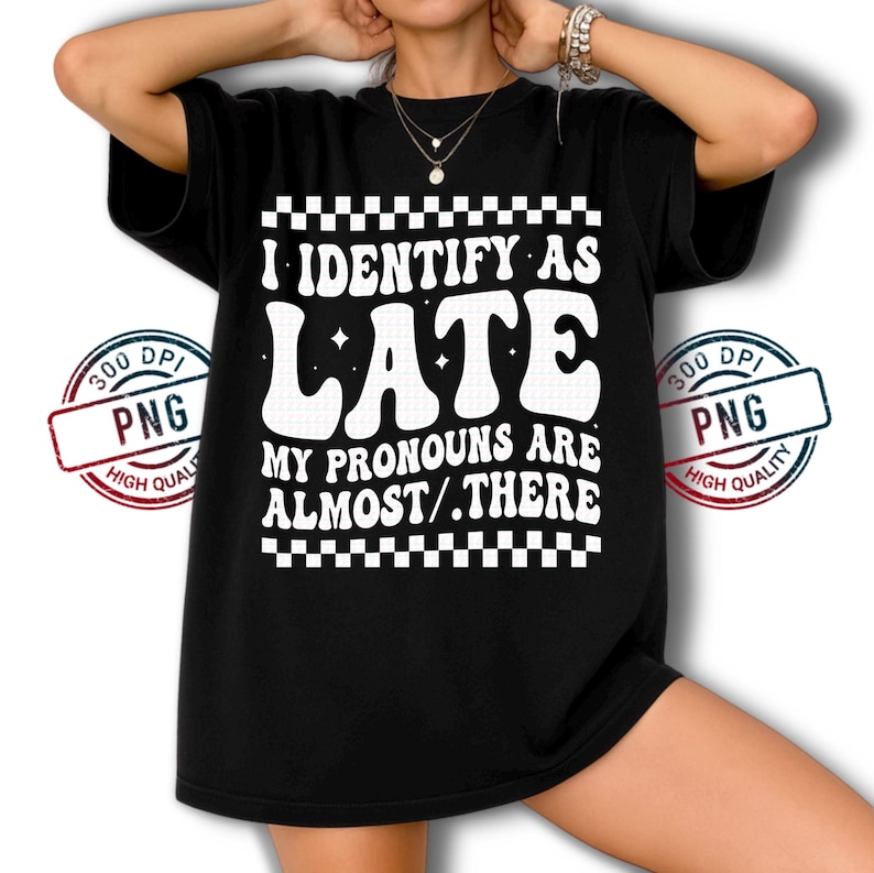 May include: Black t-shirt with the text "I IDENTIFY AS LATE. MY PRONOUNS ARE ALMOST/.THERE" in white. The text is in a retro, wavy font, with a checkered pattern above and below the text.