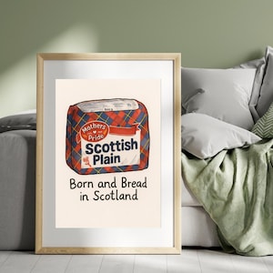 Pode incluir: Uma impressão emoldurada com uma ilustração em estilo vintage de um pão Scottish Plain. A embalagem é xadrez vermelha, azul e branca com o texto "Mothers Pride" e "Born and Bread in Scotland".