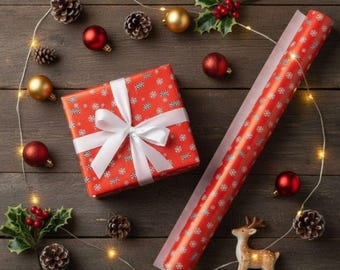 May include: A Christmas-themed arrangement featuring a wrapped present, wrapping paper, baubles, pine cones, and a small reindeer figurine. The gift is wrapped in red paper with white snowflakes and a white ribbon. Fairy lights add to the festive feel.