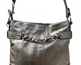 Bolso bandolera Coach para mujer en color plata metalizado con detalle de cadena.