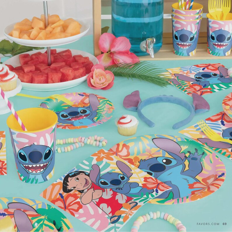 May include: A party table setting featuring Stitch themed paper plates, cups, and napkins with tropical floral patterns. The display includes a blue headband with ears, a cupcake, a tiered tray with fruit, and a blue beverage dispenser.